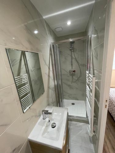 a white bathroom with a shower and a sink at studio 9 neuf et moderne in Tremblay En France