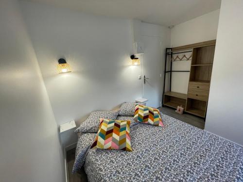a bedroom with a bed and two pillows on it at studio 9 neuf et moderne in Tremblay-En-France