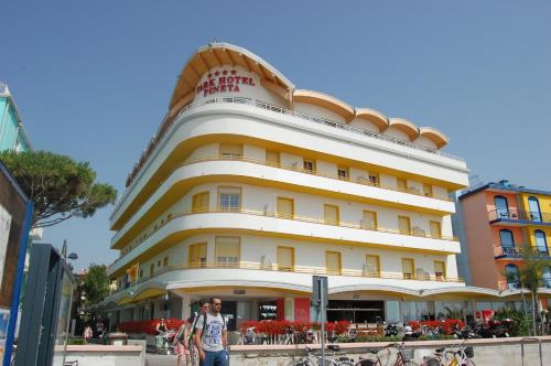 a man standing in front of a large building at Park Hotel Pineta Boutique Hotel in Caorle