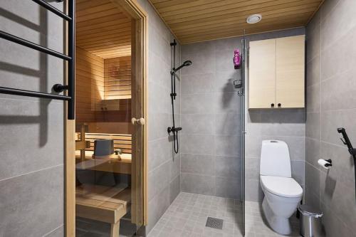 a bathroom with a toilet and a glass shower at Saunallinen uudiskohde Logomon vieressä, ilmainen autohallipaikka + Wi-Fi in Turku