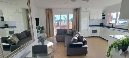 a living room with two couches and a kitchen at Mazarron Beach apartment in Mazarrón