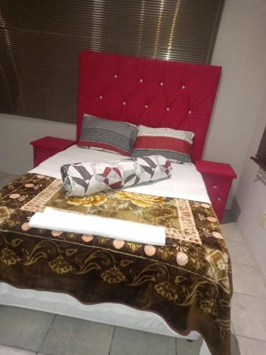 范德拜爾帕克的住宿－RIVER INN GUEST H，一张大床,配有红色床头板和枕头