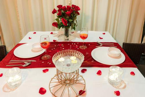 a table with red roses and a vase of flowers at Shivsagar Resort & Spa in Mahabaleshwar
