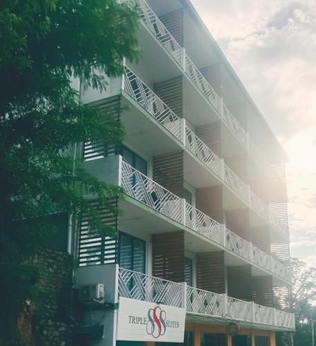 a white building with a sign in front of it at Triple 8 Suites in Labuan Bajo