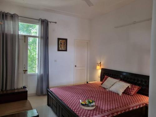Un dormitorio con una cama con un tazón de flores. en Wonthaggi, en Amritsar
