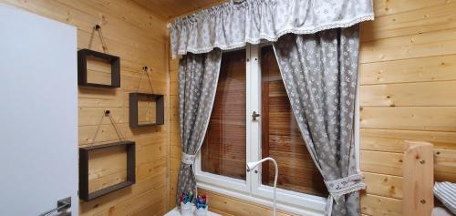 a window with curtains in a log cabin at Geofond Chaty in Chotěboř