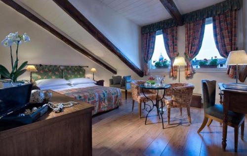 a hotel room with a bed and a table and chairs at Best Western Hotel Piemontese in Turin