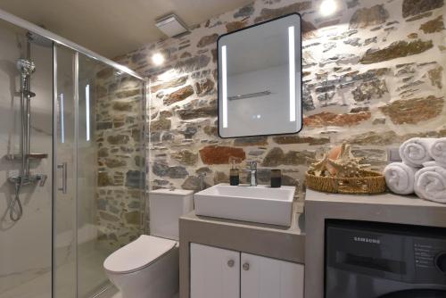 a bathroom with a toilet and a sink and a mirror at Alesio's house in Ermoupoli