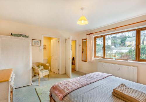 ein Schlafzimmer mit einem großen Bett und einem Fenster in der Unterkunft Alvaston in Looe