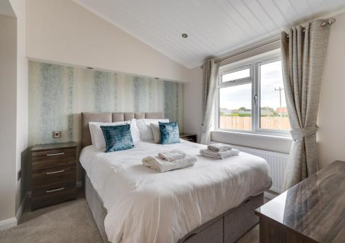 a bedroom with a large bed with towels on it at Briargate 38 in Burnham Market