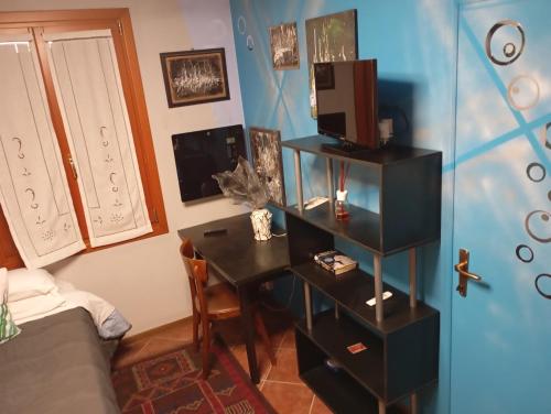 a bedroom with a desk with a tv and a bed at 49 Le Contesse Ide in Meolo