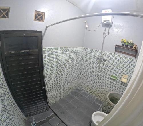 y baño con ducha y puerta de cristal. en Omahku Mbanciro, en Demangan