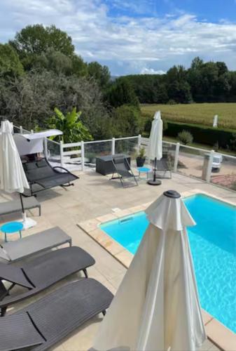 une terrasse avec des chaises longues et une piscine dans l'établissement GITE des teilles, à Carlux