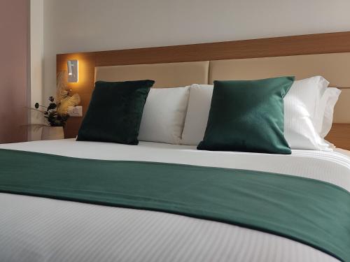 a bedroom with a bed with green and white pillows at Massimi City Garden in Rome