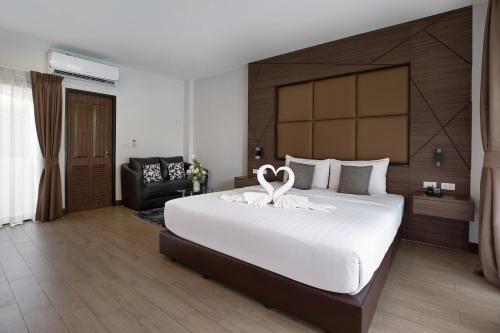 a bedroom with a large bed with a swan on it at The Bell Airport Phuket Hotel - SHA Extra Plus in Nai Yang Beach