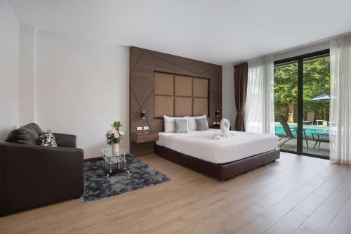 a bedroom with a large bed and a pool at The Bell Airport Phuket Hotel - SHA Extra Plus in Nai Yang Beach
