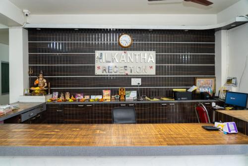 a restaurant with a counter with a clock on a wall at Hotel Nilkantha in Mandarmoni