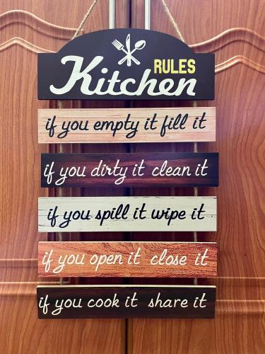 a sign that reads rules kitchen if you empty it till it if you dirty it at Stress-Free Cozy Private Room - heart of the city in Abu Dhabi