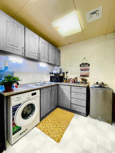 a kitchen with a washing machine and a washer at Stress-Free Cozy Private Room - heart of the city in Abu Dhabi