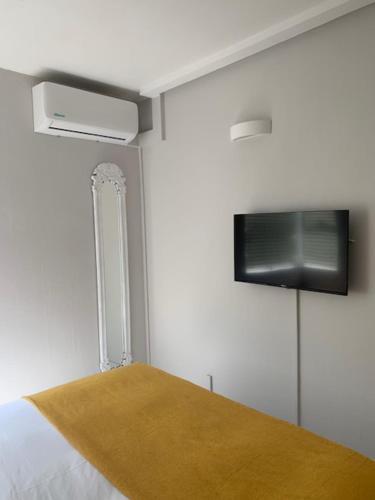 a bedroom with a bed and a tv on the wall at Chaka's Cove 74 in Ballito