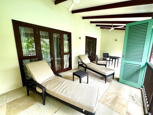 a room with two beds and chairs on a patio at Eden Island Luxury Accommodation in Eden Island