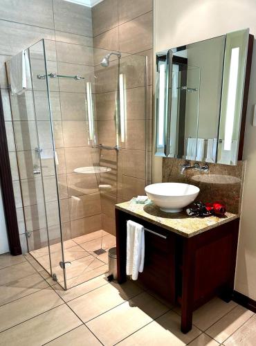 a bathroom with a sink and a glass shower at Eden Island Luxury Accommodation in Eden Island