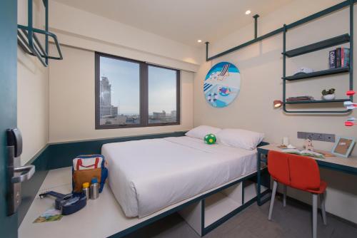 a room with a bed and a desk and a bed and a desk at lyf Cebu City managed by The Ascott Limited in Cebu City