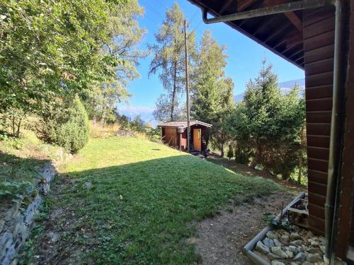 a yard with a small house in the background at Porkka COSY & QUIET chalet 8 pers in Vex