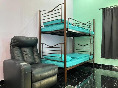 a room with two bunk beds and a chair at As Sufi Villa in Kampung Sungai Air Tawar