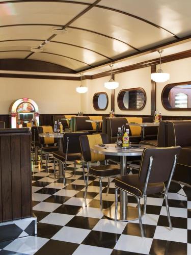 a restaurant with tables and chairs and a checkered floor at Støtvig Hotel in Moss