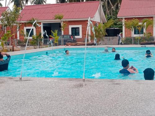 a group of people swimming in a swimming pool at As Sufi Villa in Kampung Sungai Air Tawar