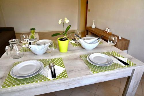 une table avec plaques blanches et argenterie dans l'établissement G & G Appartamento nuovo, moderno e grazioso., à San Nicandro Garganico