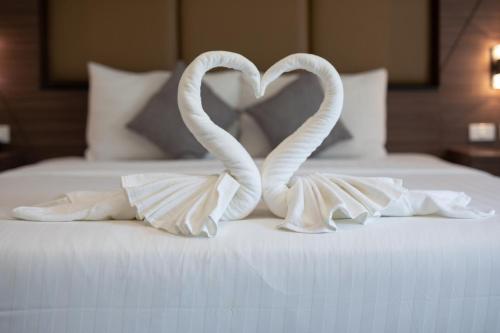 two swans making a heart on a bed at The Bell Airport Phuket Hotel - SHA Extra Plus in Nai Yang Beach