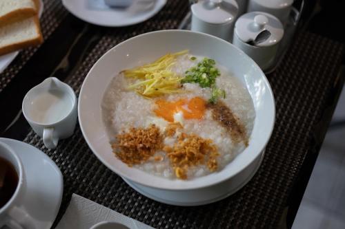 a bowl of food on a table with a plate of food at The Bell Airport Phuket Hotel - SHA Extra Plus in Nai Yang Beach