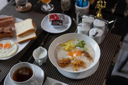 a table with a bowl of rice and a plate of food at The Bell Airport Phuket Hotel - SHA Extra Plus in Nai Yang Beach