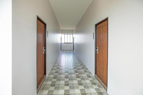 an empty hallway with two doors and a checkered floor at The Bell Airport Phuket Hotel - SHA Extra Plus in Nai Yang Beach