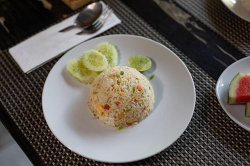 a plate of food with rice and fruit on a table at The Bell Airport Phuket Hotel - SHA Extra Plus in Nai Yang Beach