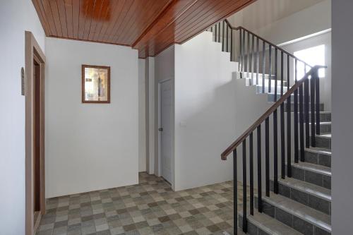 a staircase in a home with white walls and wooden ceilings at The Bell Airport Phuket Hotel - SHA Extra Plus in Nai Yang Beach