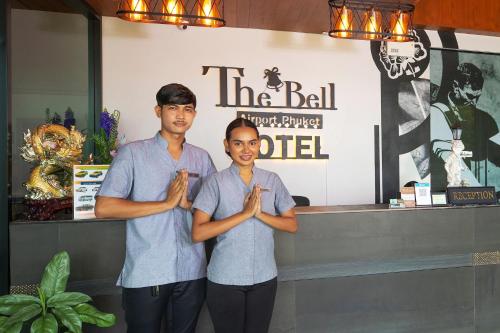 two people standing in front of a counter praying at The Bell Airport Phuket Hotel - SHA Extra Plus in Nai Yang Beach