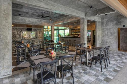 a restaurant with tables and chairs and a bar at The Bell Airport Phuket Hotel - SHA Extra Plus in Nai Yang Beach