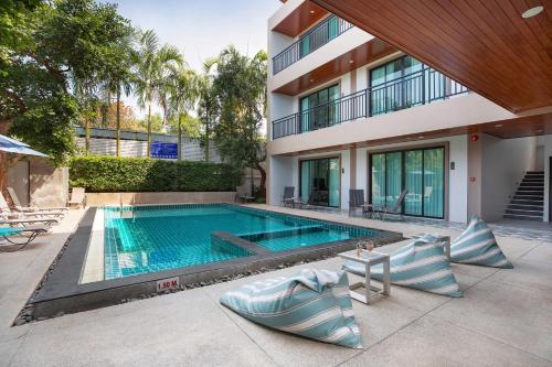 a swimming pool in front of a building at The Bell Airport Phuket Hotel - SHA Extra Plus in Nai Yang Beach