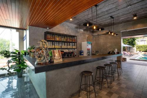a bar in a restaurant with stools at a counter at The Bell Airport Phuket Hotel - SHA Extra Plus in Nai Yang Beach
