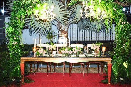 einen Tisch mit Stühlen und einen Tisch mit Blumen darauf in der Unterkunft RK Residence in Daressalam