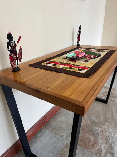a wooden table with two figurines on top of it at RK Residence in Dar es Salaam