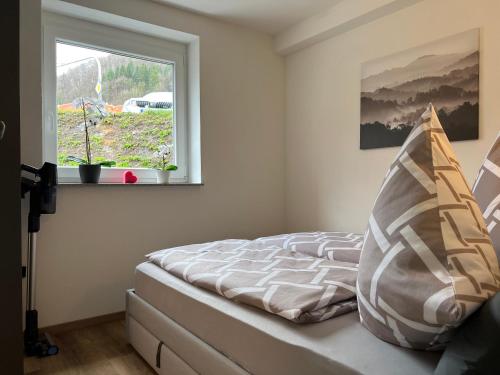 a bedroom with a bed and a window at Top Apartment Zentrum Bad Urach in Bad Urach