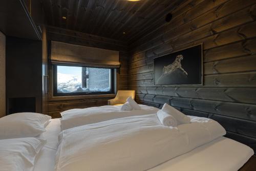a bedroom with two large white beds in it at Tindekroken 5, Hemsedal in Fausko