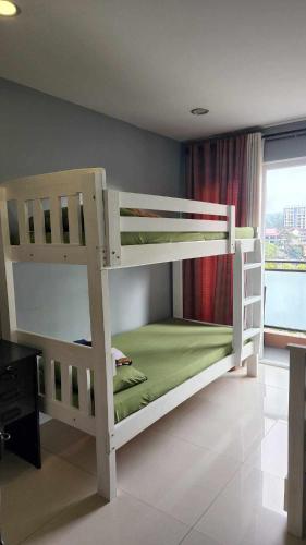 two bunk beds in a room with a window at Conifer Baguio in Baguio