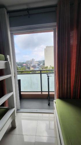 a bedroom with a large window with a view of the city at Conifer Baguio in Baguio