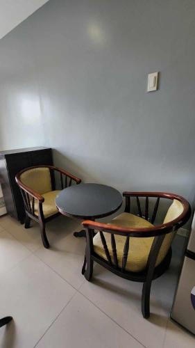 2 sillas y una mesa en una habitación en Conifer Baguio, en Baguio