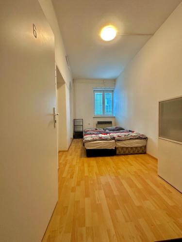 een slaapkamer met een bed en een houten vloer bij Bene Dormies in Praag